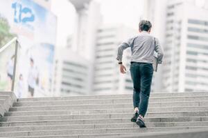 Asian businessman walking to work diligently and briskly in the morning in a big city. A man in a business suit, dressed in a smart suit, runs to work during rush hour in corridors and stairs. photo