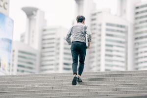 Asian businessman walking to work diligently and briskly in the morning in a big city. A man in a business suit, dressed in a smart suit, runs to work during rush hour in corridors and stairs. photo