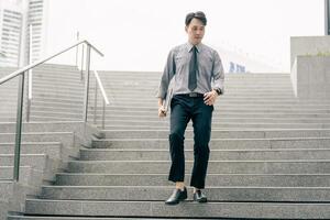 Asian businessman walking to work diligently and briskly in the morning in a big city. A man in a business suit, dressed in a smart suit, runs to work during rush hour in corridors and stairs. photo