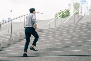 Asian businessman walking to work diligently and briskly in the morning in a big city. A man in a business suit, dressed in a smart suit, runs to work during rush hour in corridors and stairs. photo