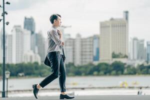 Asian businessman walking to work diligently and briskly in the morning in a big city. A man in a business suit, dressed in a smart suit, runs to work during rush hour in corridors and stairs. photo