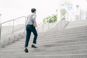 Asian businessman walking to work diligently and briskly in the morning in a big city. A man in a business suit, dressed in a smart suit, runs to work during rush hour in corridors and stairs. photo