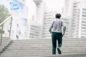 Asian businessman walking to work diligently and briskly in the morning in a big city. A man in a business suit, dressed in a smart suit, runs to work during rush hour in corridors and stairs. photo