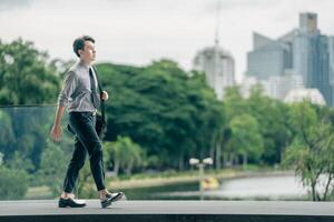 Asian businessman walking to work diligently and briskly in the morning in a big city. A man in a business suit, dressed in a smart suit, runs to work during rush hour in corridors and stairs. photo