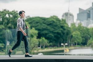 Asian businessman walking to work diligently and briskly in the morning in a big city. A man in a business suit, dressed in a smart suit, runs to work during rush hour in corridors and stairs. photo