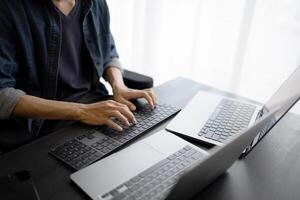 Asian man software engineer Working on Computer at office desk for writing program code IT Software Engineer finding errors tech support devops creating digital photo