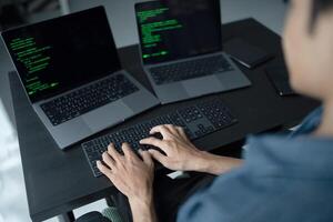 Asian man software engineer Working on Computer at office desk for writing program code IT Software Engineer finding errors tech support devops creating digital photo