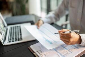 Close up of businessman hands signing or writing document paperwork and report Auditor analysis male professional hand making notes with Business Document. photo