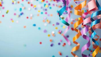 Colorful party streamers and confetti on a blue background with copy space photo