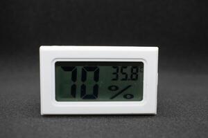 humidity measuring thermometer, small size, portable, with black background. photo