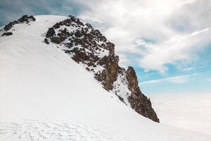 Group of Climbers reaching top mount Kazbek in Georgia. Never give up and pushing through life difficulties concept. Man working hard to climb up a mountain photo