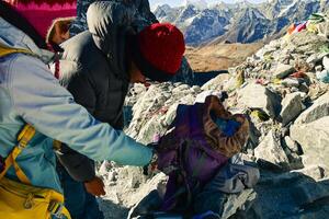 Professional nepalese guide use oxygen finger monitor to check woman trekker blood oxygen levels. Himalayas high altitude feeling low oxygen level affects of dizziness and weakness photo