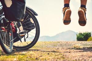 Close up bicycle by muscular legs up in air jump for fun pose playful wallpaper sportsman active well-being men. Sports and healthy concept photo