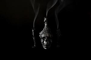 Halloween background with skull that have candle on it with another candles that have smoke on black background. Minimal concept. photo