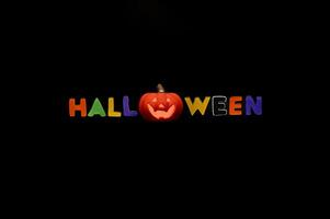 Halloween background with Jack o lantern that have light inside and alphabets gel sticker on black background. Minimal concept. photo