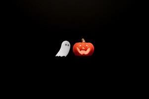 Halloween background with Jack o lantern that have light inside and white ghost sheet gel sticker on black background. Minimal concept. photo