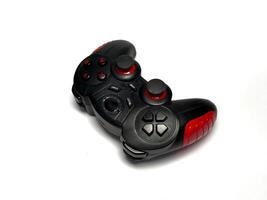 Gamepad isolated on white background. Black joystick with red and black buttons photo