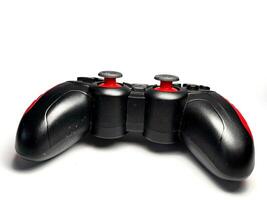 Gamepad isolated on white background. Black joystick with red and black buttons photo
