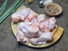 400 grams of raw chicken thighs with spices on wooden cutting board on rustic background photo