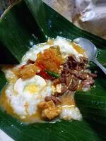 Gudeg porridge is a typical food from Yogyakarta, made from young jackfruit and cassava leaves, usually topped with boiled eggs and shredded chicken. photo