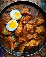 a pan with chicken and boiled eggs in it photo