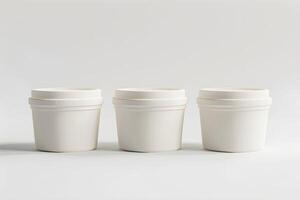 Three white cups with lids on a white surface photo