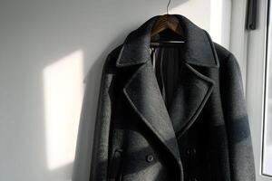 A coat hanging on a wall near a window photo