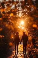 Couple holding hands walking through the woods at sunset photo