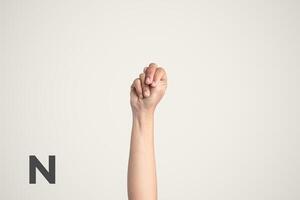 Deaf Sign alphabet of N, American Sign Language ASL. Isolated object Finger spelling the alphabet photo