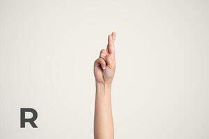 Deaf Sign alphabet of R, American Sign Language ASL. Isolated object Finger spelling the alphabet photo