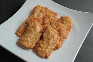crispy flour fried tempeh which is served on a plate. photo