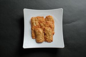 crispy flour fried tempeh which is served on a plate. photo