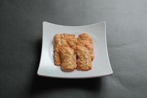 crispy flour fried tempeh which is served on a plate. photo