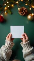 Holding a blank card with Christmas decorations in the background photo