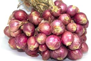 Shallots are a staple for cooking, it is an essential spice that people around the world love to eat and cook. It smells good, adds flavor to more delicious dishes on a white background. photo