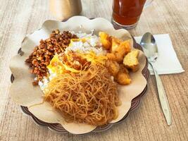 Traditional Indonesian Nasi Uduk with Various Side Dishes, Orek Tempe, Krecek photo