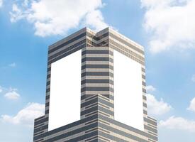Mock up two white vertical LED display billboard on tower building with blue sky background .clipping path for mockup photo