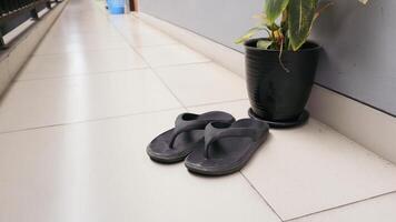 Black flip flops outside the house photo