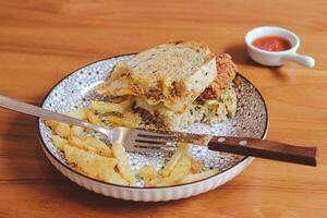 Whole wheat sandwich toast with crispy chicken, sunny side egg, and sauce. Breakfast concept in the morning photo