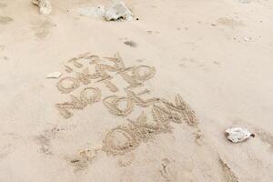 Motivation quotes it is okay not to be okay written in the sand of the beach photo