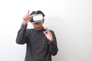 Portrait of Asian man in black plaid shirt using Virtual Reality VR glasses and trying to touch something in front of him. Isolated image on white background photo