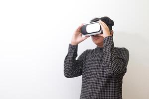 Portrait of Asian man in black plaid shirt using Virtual Reality VR glasses and looking up. Isolated image on white background photo