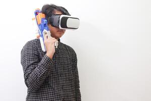 Portrait of Asian man in black plaid shirt using Virtual Reality VR glasses holding a gun weapon console. Isolated image on white background photo