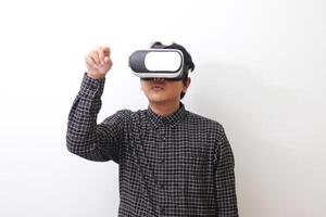 Portrait of Asian man in black plaid shirt using Virtual Reality VR glasses and trying to touch something in front of him. Isolated image on white background photo