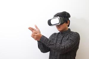 Portrait of Asian man in black plaid shirt using Virtual Reality VR glasses and greet his friend inside the game with opened palm. Isolated image on white background photo