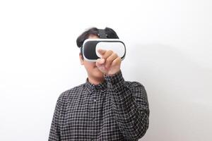 Portrait of Asian man in black plaid shirt using Virtual Reality VR glasses and trying to touch something in front of him. Isolated image on white background photo