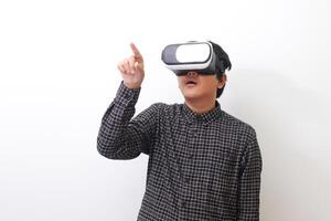 Portrait of Asian man in black plaid shirt using Virtual Reality VR glasses and trying to touch something in front of him. Isolated image on white background photo