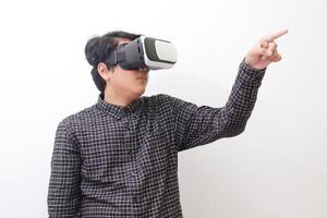 Portrait of Asian man in black plaid shirt using Virtual Reality VR glasses and trying to touch something in front of him. Isolated image on white background photo
