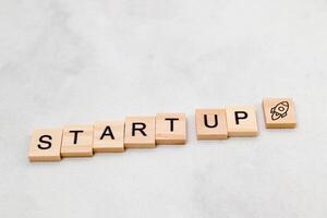 Top view of Start Up word on wooden cube letter block on white background. Business concept photo
