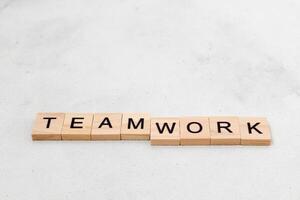 Top view of Teamwork word on wooden cube letter block on white background. Business concept photo